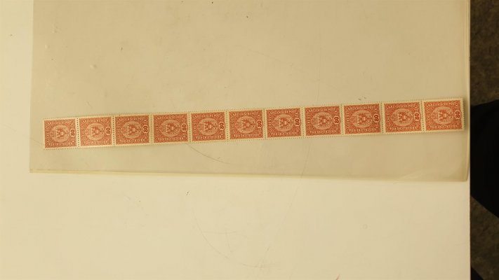 45; dlouhá páska rakouských známek o 11 kusech hodnoty 80 h červenohnědá, 11 známek jasně a prokazatelně dokládá fakt, že tato páska pochází ze svitku (), velmi vzácné, katalog neuvádí, vodorovně v perforaci kvůli velikosti několikrát přeloženo, hledaná páska